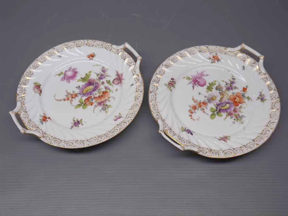 Pair of Dresden circular two-handled plates with floral painted centres and gilt borders,approx