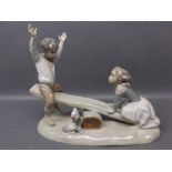 Spanish Nao figure,of young boy and girl on a seesaw,10ins wide x 8ins tall