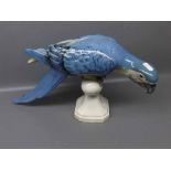 Royal Dux model of a blue macaw perched on a stand in typical inquisitive stance,decorated in