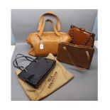 Tan leather bag containing three assorted handbags to include a black gloss Tula handbag,faux