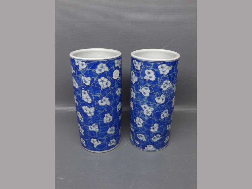 Pair of 20th century Oriental cylindrical vases with blue ground, repeating floral design, 4ins