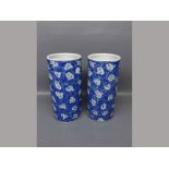 Pair of 20th century Oriental cylindrical vases with blue ground, repeating floral design, 4ins