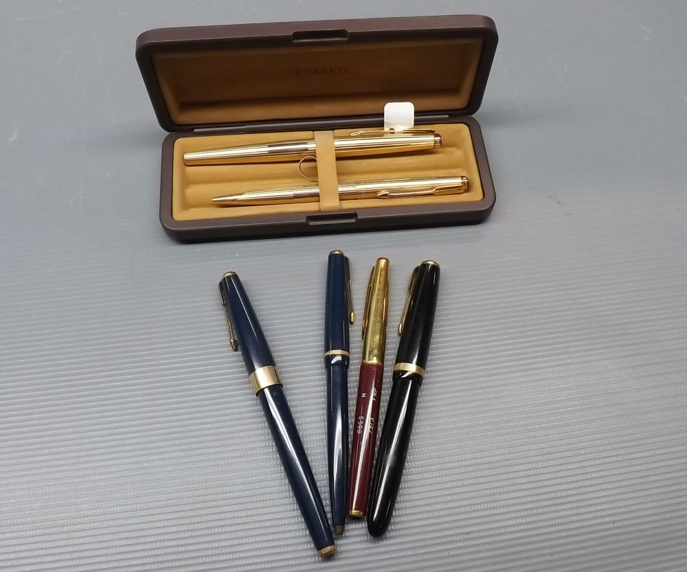 Gold plated fountain pen and matching pen in case, together with three further Parker pens,