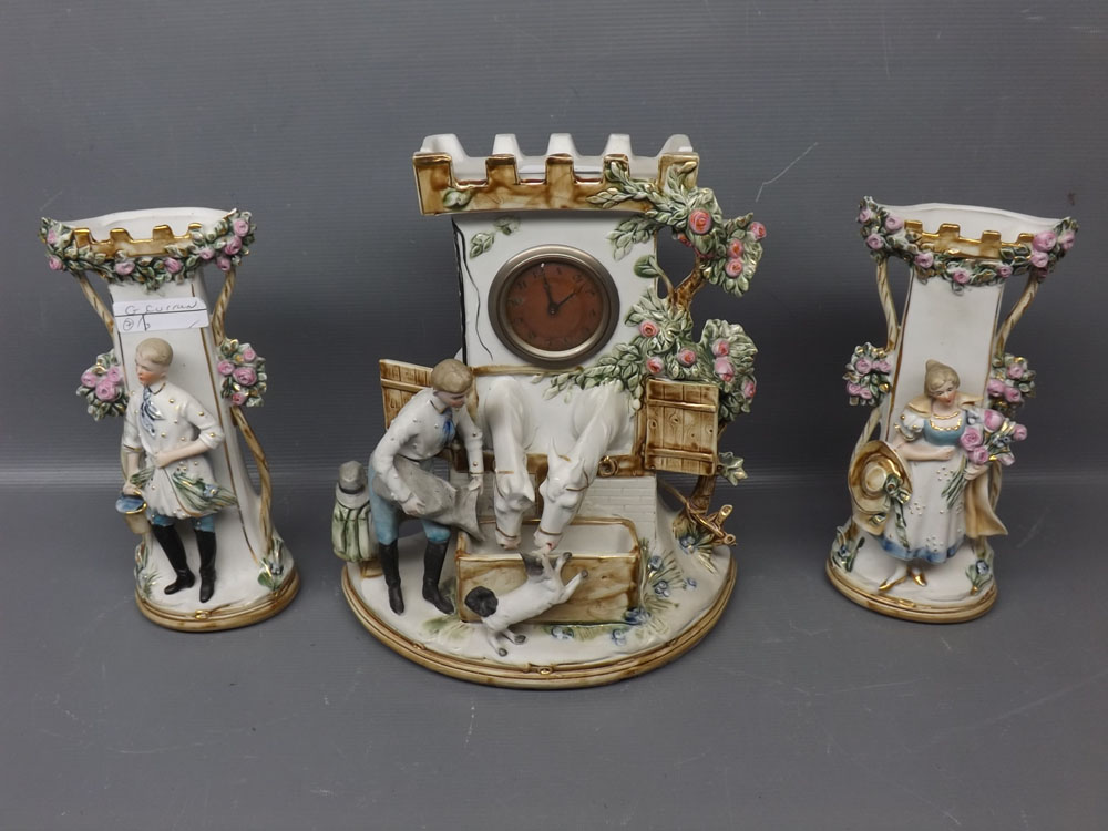 Continental clock garniture modelled as a young boy feeding two horses coming out of stable doors,