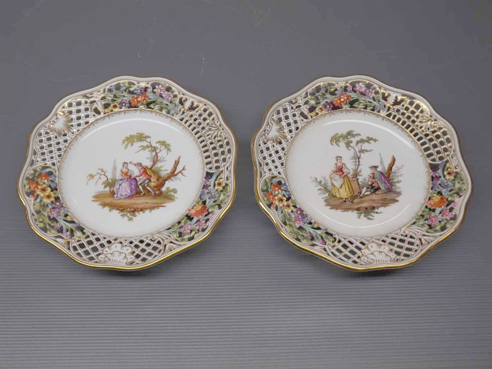 Pair of 19th century Meissen plates with painted figure centres, open work edge, painted floral