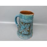 C H Brannam Newport Pottery jug with two panels depicting animals with raised blue design, brown