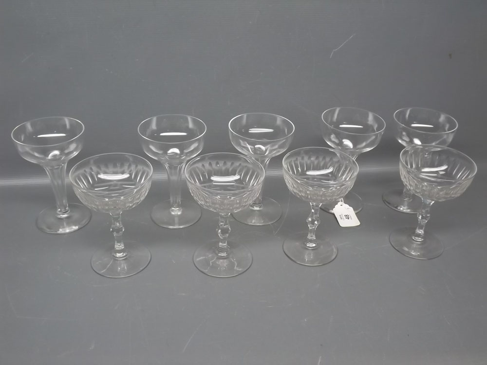 Set of five clear glass champagne glasses, with fluted stems, together with a further set of four