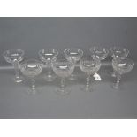 Set of five clear glass champagne glasses, with fluted stems, together with a further set of four