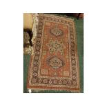 Caucasian carpet decorated in rust ground, with geometric floral design and multi-gulled border,