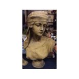 Composition limestone coloured bust of a young girl wearing a headscarf, raised on circular