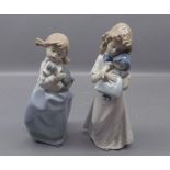 Two figures: one modelled as a young girl holding a dolly and the other of a young girl with