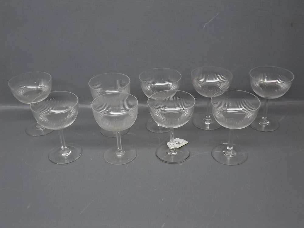 Set of nine clear glass champagne glasses with ribbed decoration, each 5ins tall