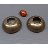 Pair of oriental bronze candle holders of domed form with etched decoration, together with a further