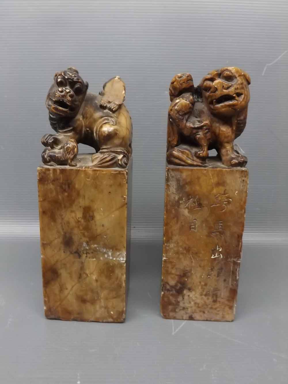 A pair of 19th century Chinese soapstone seals with lion dog and pup finials, one with an