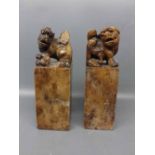 A pair of 19th century Chinese soapstone seals with lion dog and pup finials, one with an