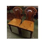 Pair of 19th century mahogany hall chairs, with shaped and openwork backs and hard seats with canted