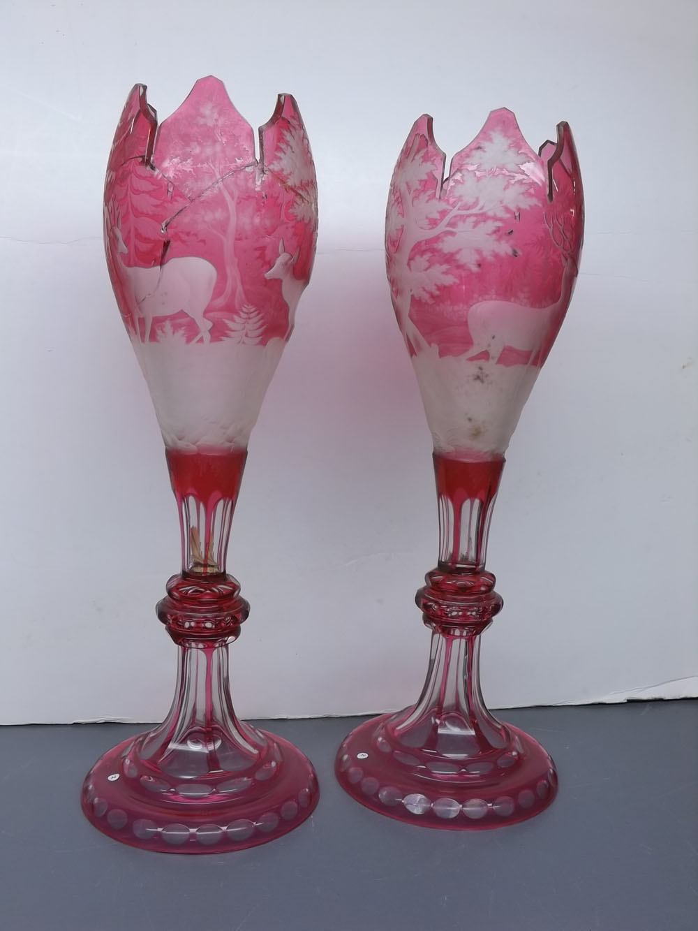 Pair of 19th century cranberry Bohemian glass vases, with etched decoration of stag in a wooded