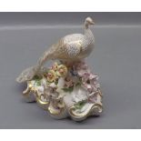 Early 19th century Crown Derby figure, modelled as a peacock among a foliage style crown with gilded
