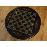 Black slate circular table top with floral and chequerboard painted detail, 17ins diameter