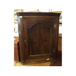 18th century oak framed wall mounted corner cupboard with single oak arched panelled door with three