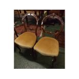 Pair of walnut carved balloon back dining chairs, with heavily carved foliage back with beige