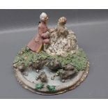 Capodimonte figure group of a seated lady and gent by pond side, with marshy bank and stone