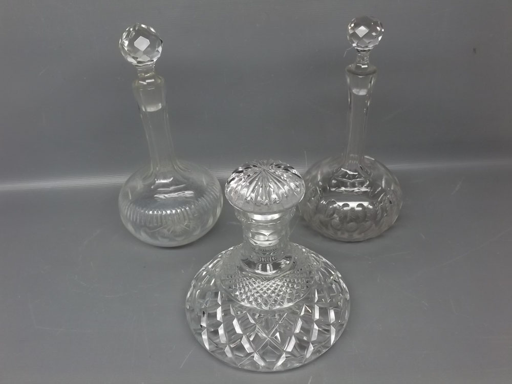 Near pair of clear glass decanters with bulbous base, canted neck and faceted stopper, together with