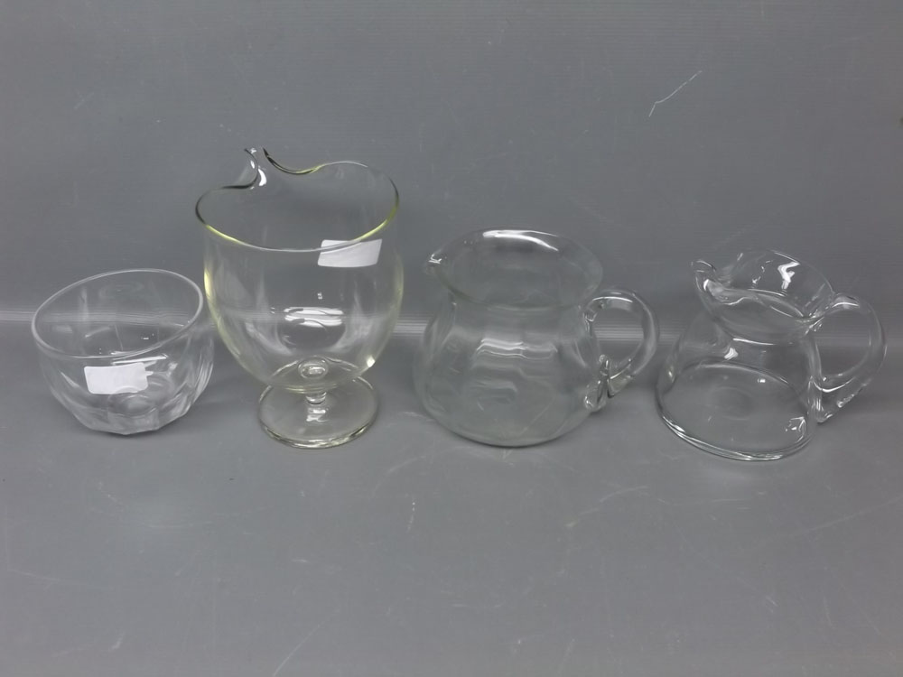 Mixed Lot: three mid-20th century clear glass water jugs with shaped handles and of bulbous form;