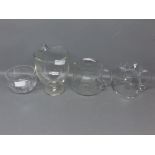 Mixed Lot: three mid-20th century clear glass water jugs with shaped handles and of bulbous form;