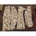 Two pairs of chintz cream ground decorated curtains, each 25ins x 56ins and 42ins x 56ins