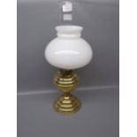 Small brass Victorian oil lamp, on circular base with stepped design with an opaque shade and