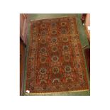 Caucasian designed carpet with rust ground with repeating floral designs, with multi gulled