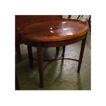 20th century mahogany tray table of oval form with shaped rim and brass carriage handles to an