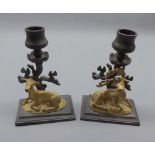 Pair of bronze candlesticks with mounted gilt stag and doe, on a rectangular plinth, 5 1/2 ins tall