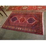 Red and blue ground Hamadan rug with three lozenges centrally with decorative border, 53ins x 77ins