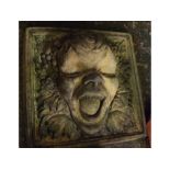 Composition square formed tile with raised decoration of the green man, 11 ins square