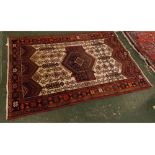 Persian rug decorated in mainly red, blue and cream ground with central blue diamond lozenge and