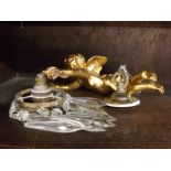 Resin gilt model of a putto formed as a wall light, holding a single sconce with glass droplet