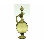 Pale green glass claret jug with conical stopper, wrythen handle and wrythen ovoid body