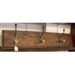 Oak framed coat rack with three fitted hooks with porcelain detail, 37ins wide x 8ins tall