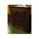 18th century oak framed wall mounted corner cupboard with single oak arched panelled door with three