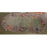 Modern oval Chinese green ground carpet with floral border, 35 x 69ins