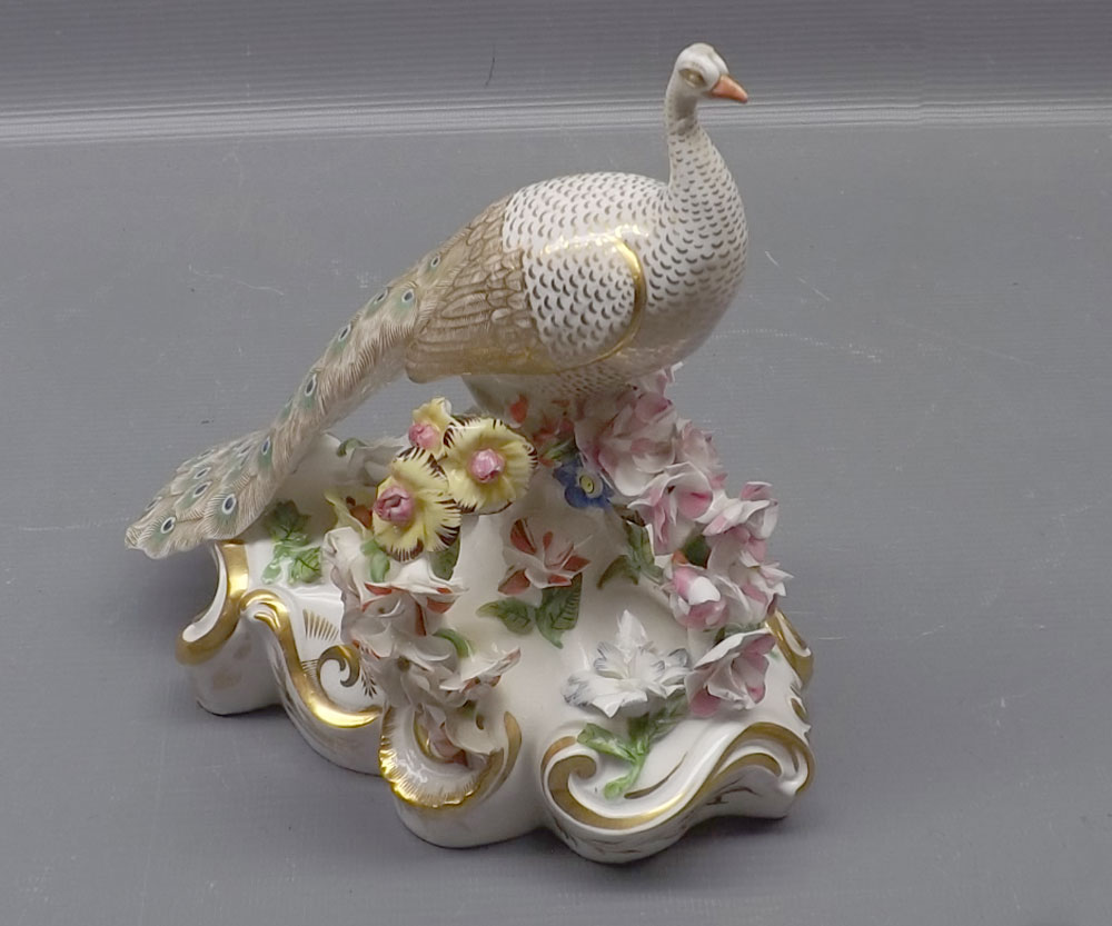 Early 19th century Crown Derby figure, modelled as a peacock among a foliage style crown with gilded