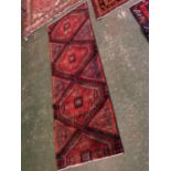 Woollen carpet runner fragment, with predominantly blue field and red replicating geometric