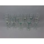 Group of 11 20th century green tinted wine glasses of varying sizes, tallest 7ins tall