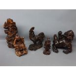 Three Chinese root carved figures to include a Fo dog with glass eyes, a seated sage, a resin