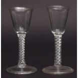 Two 20th century wine glasses, each with conical bowls and inter-laced air twist stems, raised on