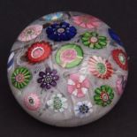 Clichy paper weight with scattered coloured rosettes on a white cane ground, 2 1/2 ins diam
