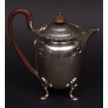 George V hot water pot, the oval body with flared rim and hinged and domed cover raised on four cast