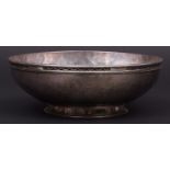 Late George V shallow bowl of hammered construction with applied rim and raised on a flared circular